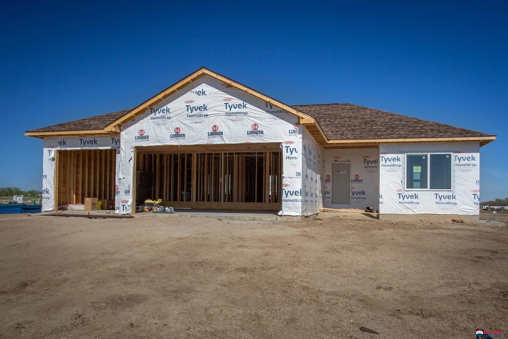 property in mid-construction with roof with shingles and a garage