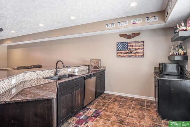 interior space featuring a sink, stainless steel dishwasher, baseboards, and dark stone counters