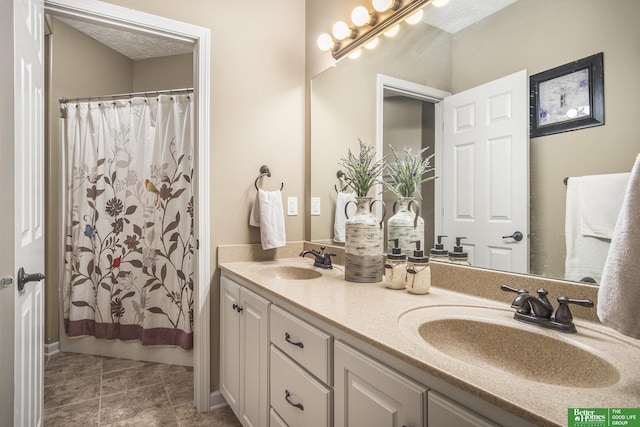 bathroom featuring a shower with curtain, double vanity, and a sink