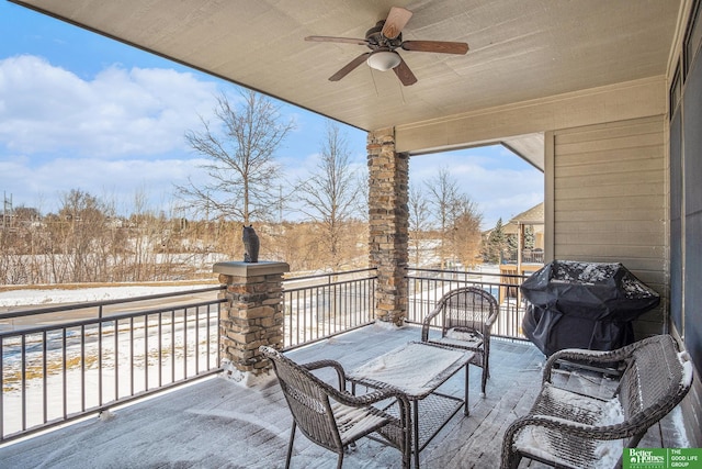 snow covered patio with a ceiling fan, a balcony, and area for grilling