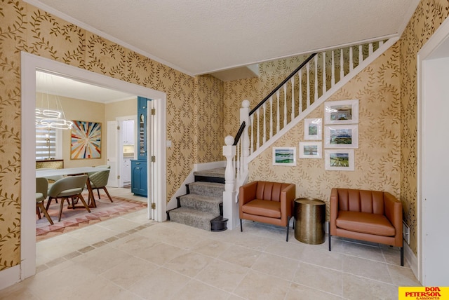 1638 N Nye Ave, Fremont, NE 68025 - stairway featuring a notable chandelier, wallpapered walls, a textured ceiling, tile patterned flooring, and crown molding