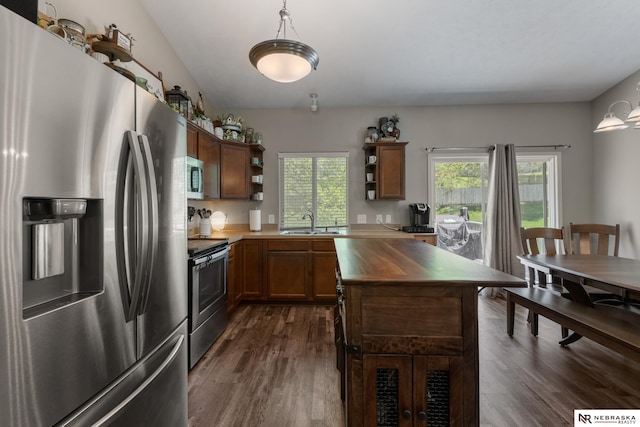 kitchen with a sink, dark wood-style flooring, open shelves, and appliances with stainless steel finishes