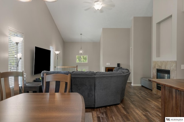living room with high vaulted ceiling, a fireplace, a ceiling fan, dark wood-style floors, and baseboards