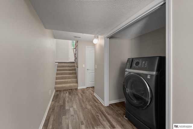 laundry room featuring laundry area, wood finished floors, baseboards, and washer / clothes dryer