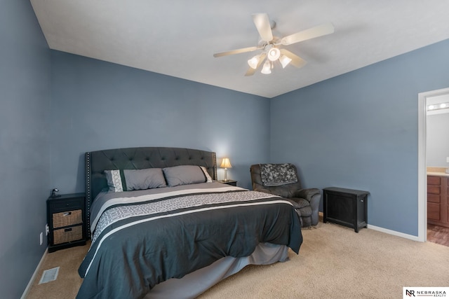 bedroom featuring ensuite bath, carpet floors, baseboards, and a ceiling fan