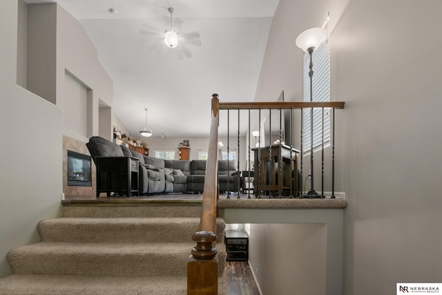 staircase featuring ceiling fan, lofted ceiling, and wood finished floors