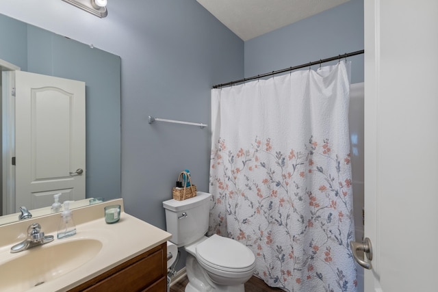 bathroom with toilet, vanity, and a shower with curtain