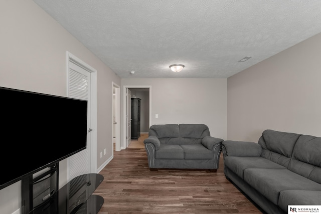 living room with a textured ceiling and wood finished floors