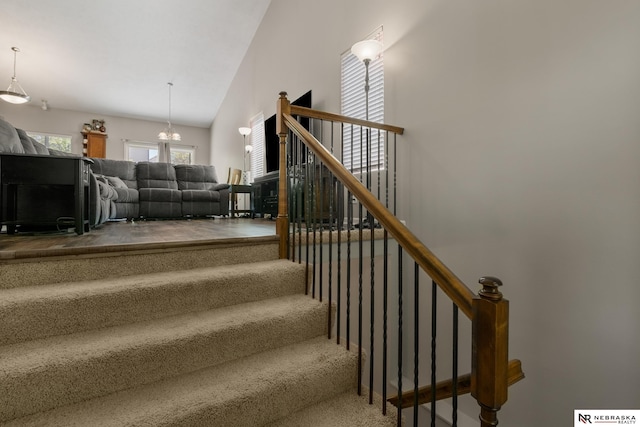 stairs with carpet flooring and high vaulted ceiling