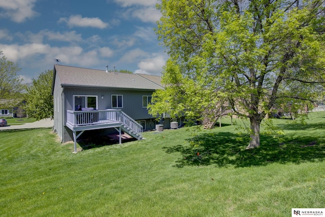 back of property featuring a yard, stairway, a wooden deck, and a shingled roof