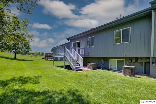 back of house featuring a yard, cooling unit, stairway, and a wooden deck