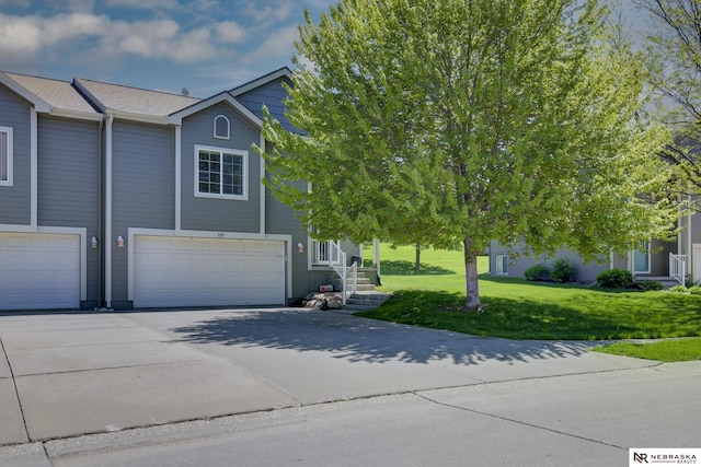 view of front of home with a garage, a front lawn, and driveway