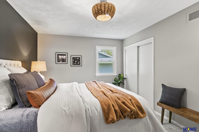 carpeted bedroom featuring baseboards, a closet, and visible vents