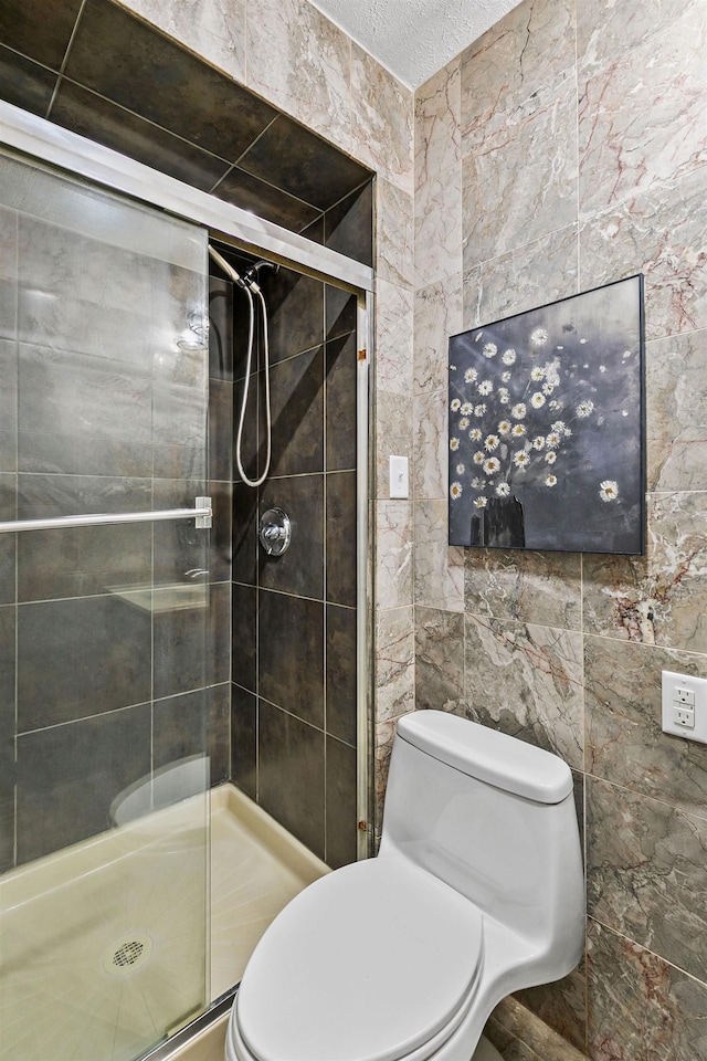 full bath with toilet, tile walls, and a stall shower