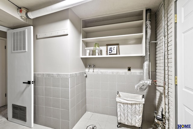 bathroom with tile walls, tile patterned flooring, and wainscoting