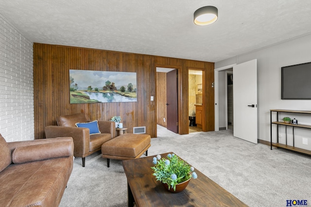 living room featuring wooden walls, brick wall, visible vents, and carpet