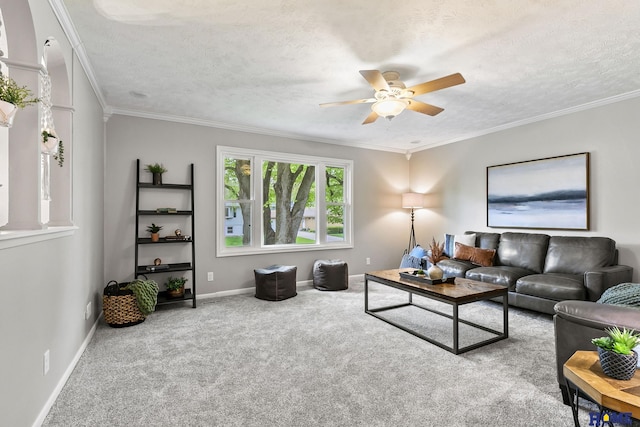 living room with carpet flooring, ornamental molding, baseboards, and ceiling fan