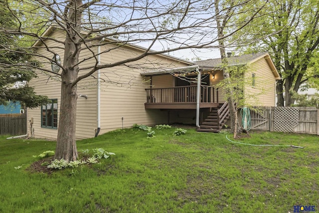back of house featuring a lawn, fence, a deck, and stairs