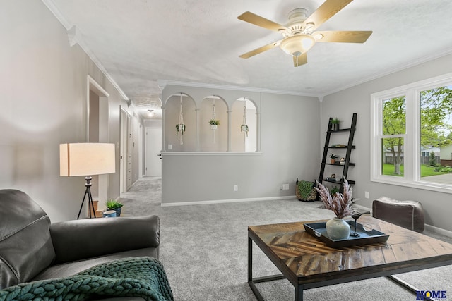 living room with carpet flooring, ornamental molding, a ceiling fan, and baseboards
