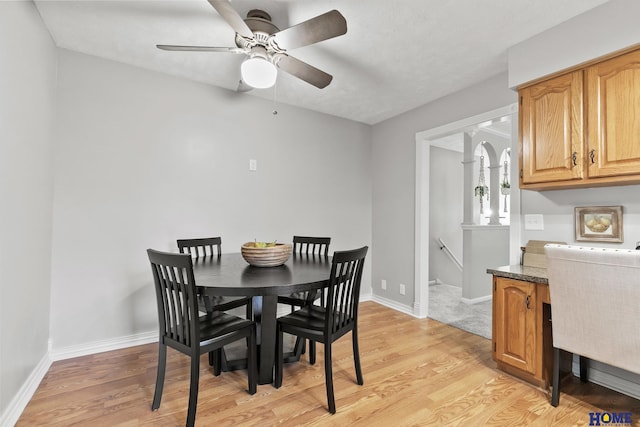 dining space featuring light wood-type flooring, baseboards, and a ceiling fan