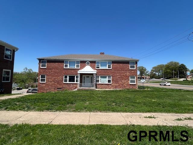 view of front of property featuring brick siding and a front yard