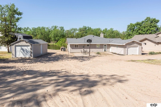 S-1129 Platte Shore Dr, Fremont, NE 68025 - view of front of property with a detached garage, an outdoor structure, and a chimney