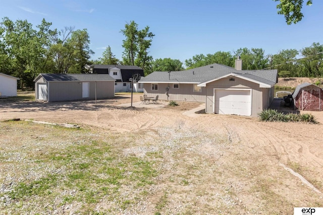 S-1129 Platte Shore Dr, Fremont, NE 68025 - view of yard featuring an attached garage, dirt driveway, and an outbuilding