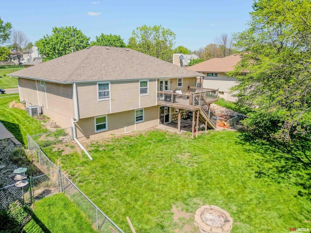 rear view of house featuring a lawn, a wooden deck, a fenced backyard, and stairs