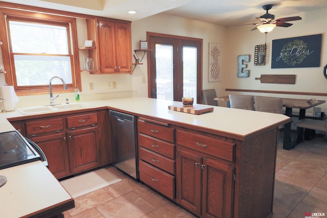 kitchen featuring a sink, a peninsula, dishwasher, ceiling fan, and light countertops