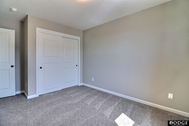 unfurnished bedroom with a closet, baseboards, and carpet floors