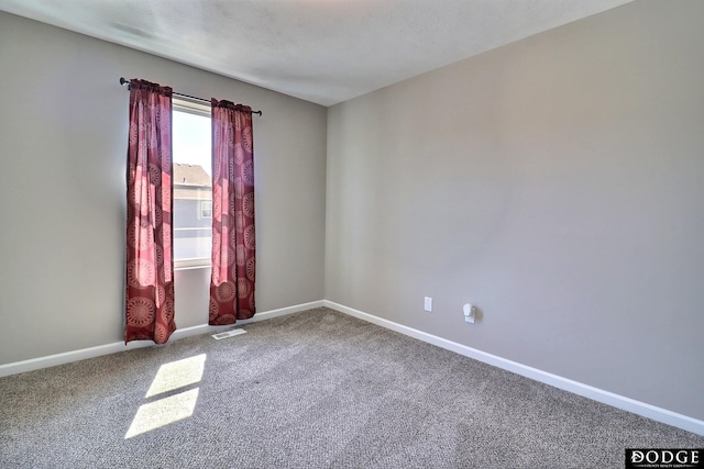 carpeted empty room with baseboards and visible vents