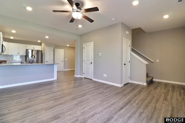 unfurnished living room featuring wood finished floors, a ceiling fan, and recessed lighting
