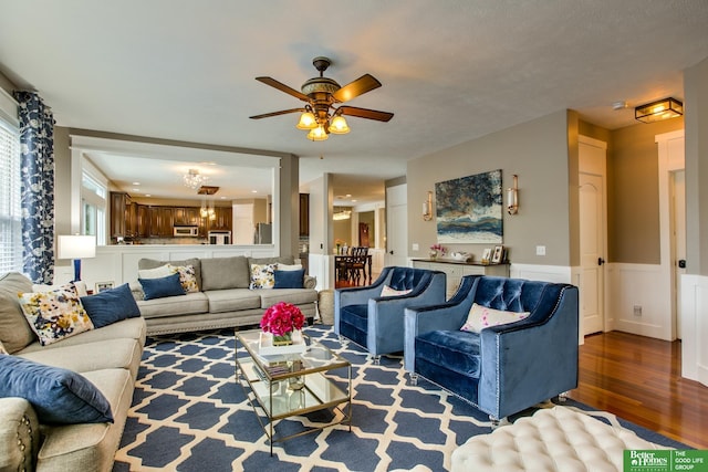 living area featuring wainscoting, a ceiling fan, and wood finished floors