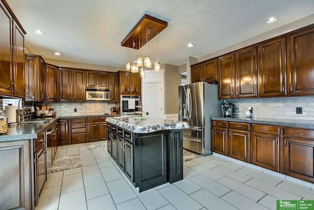 kitchen with light tile patterned floors, hanging light fixtures, stainless steel appliances, and decorative backsplash