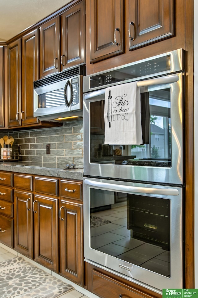 kitchen with dark countertops, stainless steel appliances, and tasteful backsplash