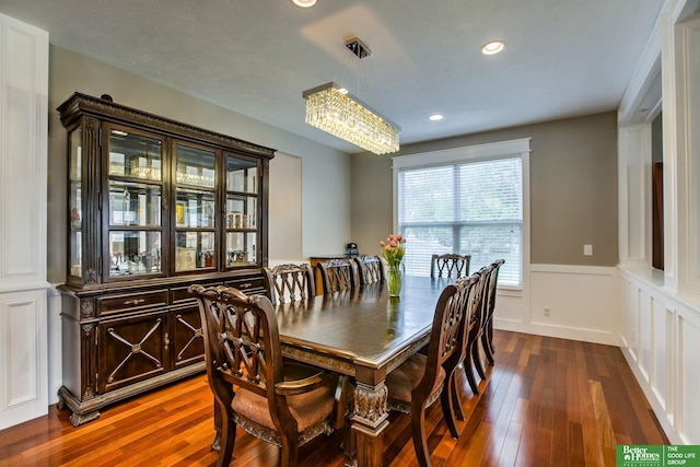 dining space featuring recessed lighting, a notable chandelier, wood-type flooring, and a wainscoted wall
