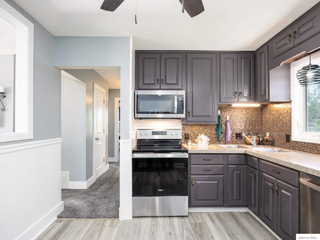7521 Edward Ave, La Vista, NE 68128 - kitchen with appliances with stainless steel finishes, ceiling fan, a sink, light wood finished floors, and gray cabinetry