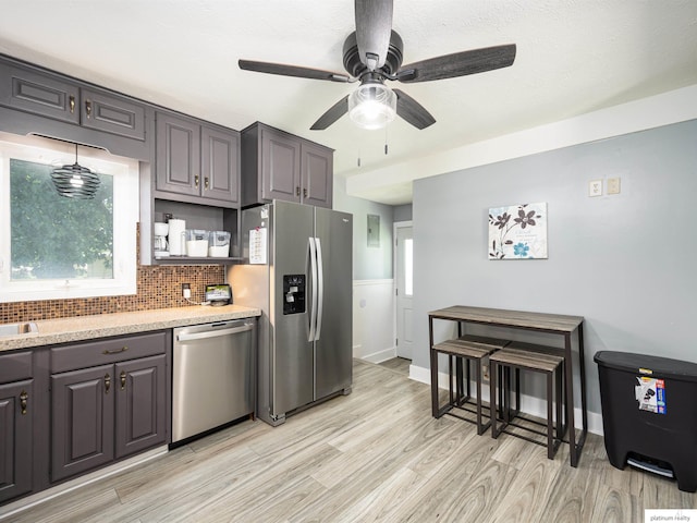 7521 Edward Ave, La Vista, NE 68128 - kitchen with appliances with stainless steel finishes, light wood-type flooring, light countertops, backsplash, and a ceiling fan