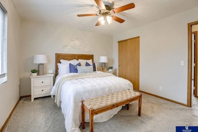 carpeted bedroom with baseboards, a closet, and ceiling fan