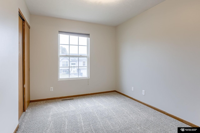 unfurnished bedroom with baseboards, visible vents, and light colored carpet