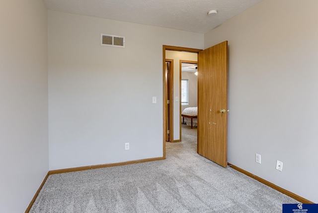 carpeted spare room with baseboards and visible vents
