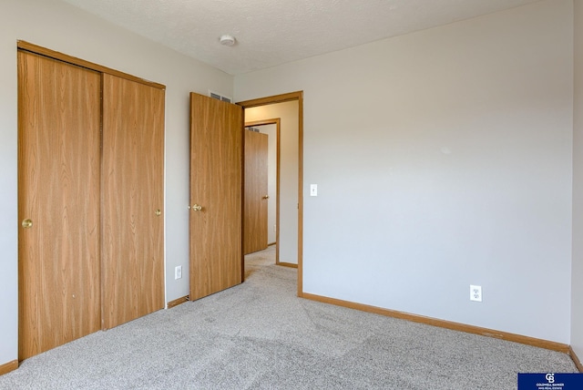 unfurnished bedroom with baseboards, a closet, visible vents, and carpet