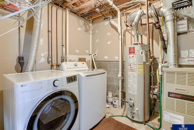 clothes washing area with laundry area, water heater, independent washer and dryer, and heating unit