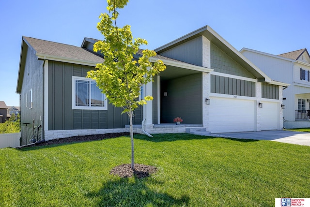view of front of home featuring concrete driveway, board and batten siding, a front yard, and a garage