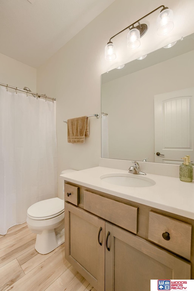 full bathroom with toilet, wood finished floors, vanity, and a shower with curtain