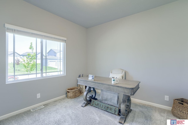 carpeted office with baseboards and visible vents