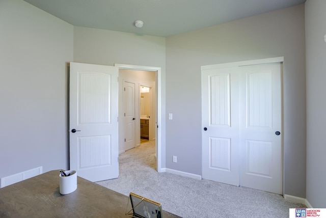 unfurnished bedroom with carpet floors, baseboards, visible vents, and a closet