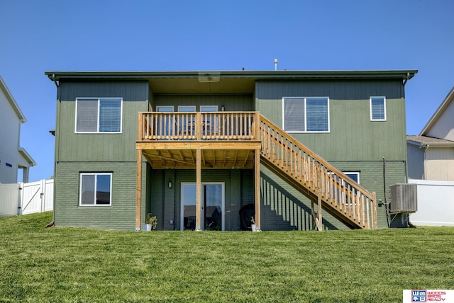 rear view of house with a lawn, fence, stairway, a wooden deck, and a gate