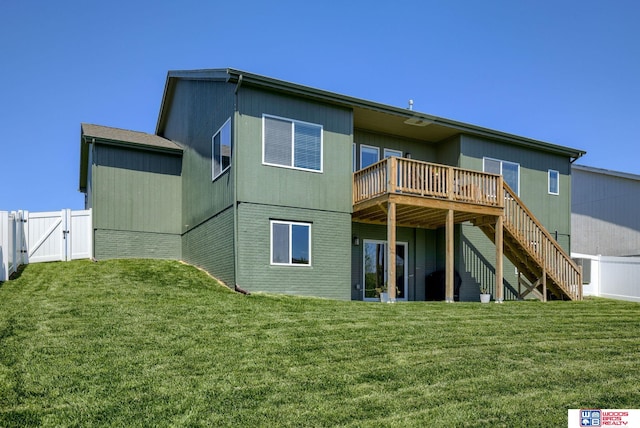 rear view of house featuring a gate, a wooden deck, stairs, and a yard