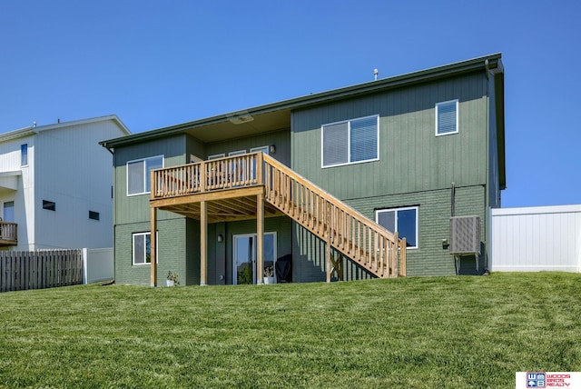 back of property with a yard, a deck, stairway, and fence
